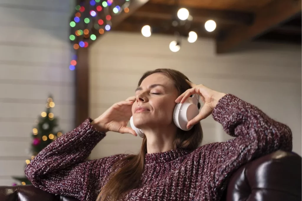 Kobieta w białych słuchawkach relaksująca się przy muzyce - nauka angielskiego przez piosenki i świąteczne karaoke online ze SpeakPro Academy.