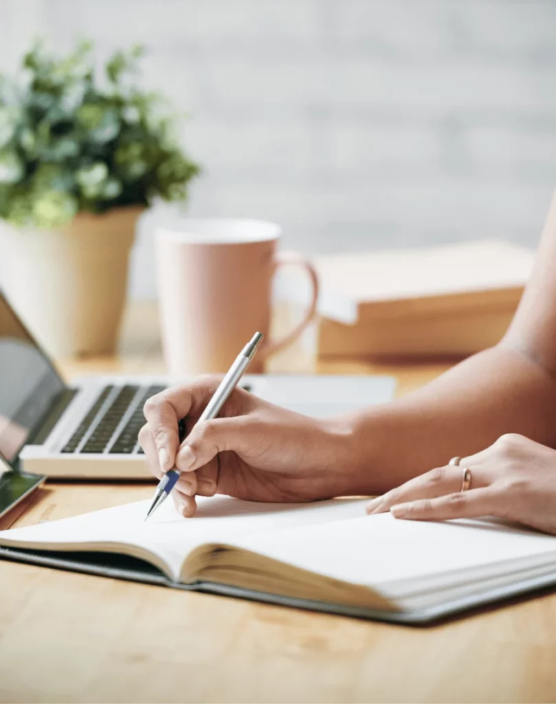 Planowanie nauki języka przy biurku z laptopem i kawą - nauka języka obcego online jako postanowienie noworoczne, które w końcu zrealizujesz.