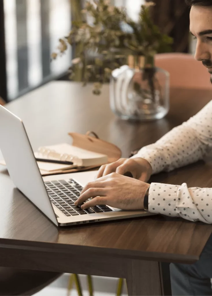 Pisanie na laptopie w biurowym otoczeniu - jak przygotować się do rozmowy o pracę w języku angielskim online, korzystając z profesjonalnych kursów SpeakPro Academy.